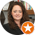 Person with curly hair and bookshelf