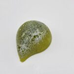 Green, shiny, teardrop-shaped chocolate