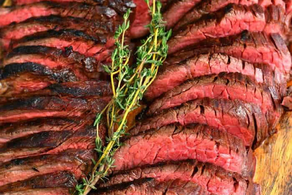 Sliced grilled meat with thyme garnish